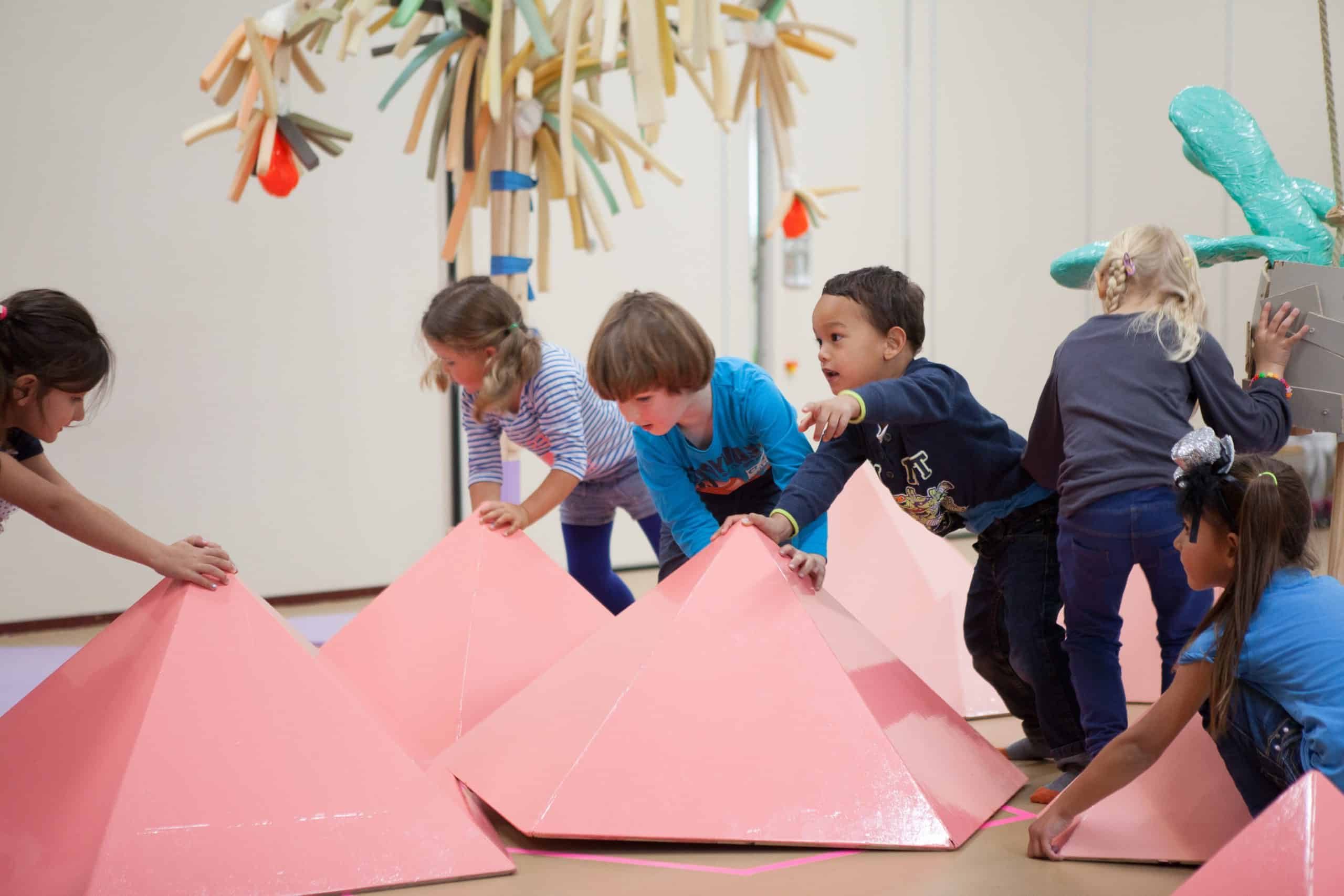 Kinderen spelen met roze pilonnen