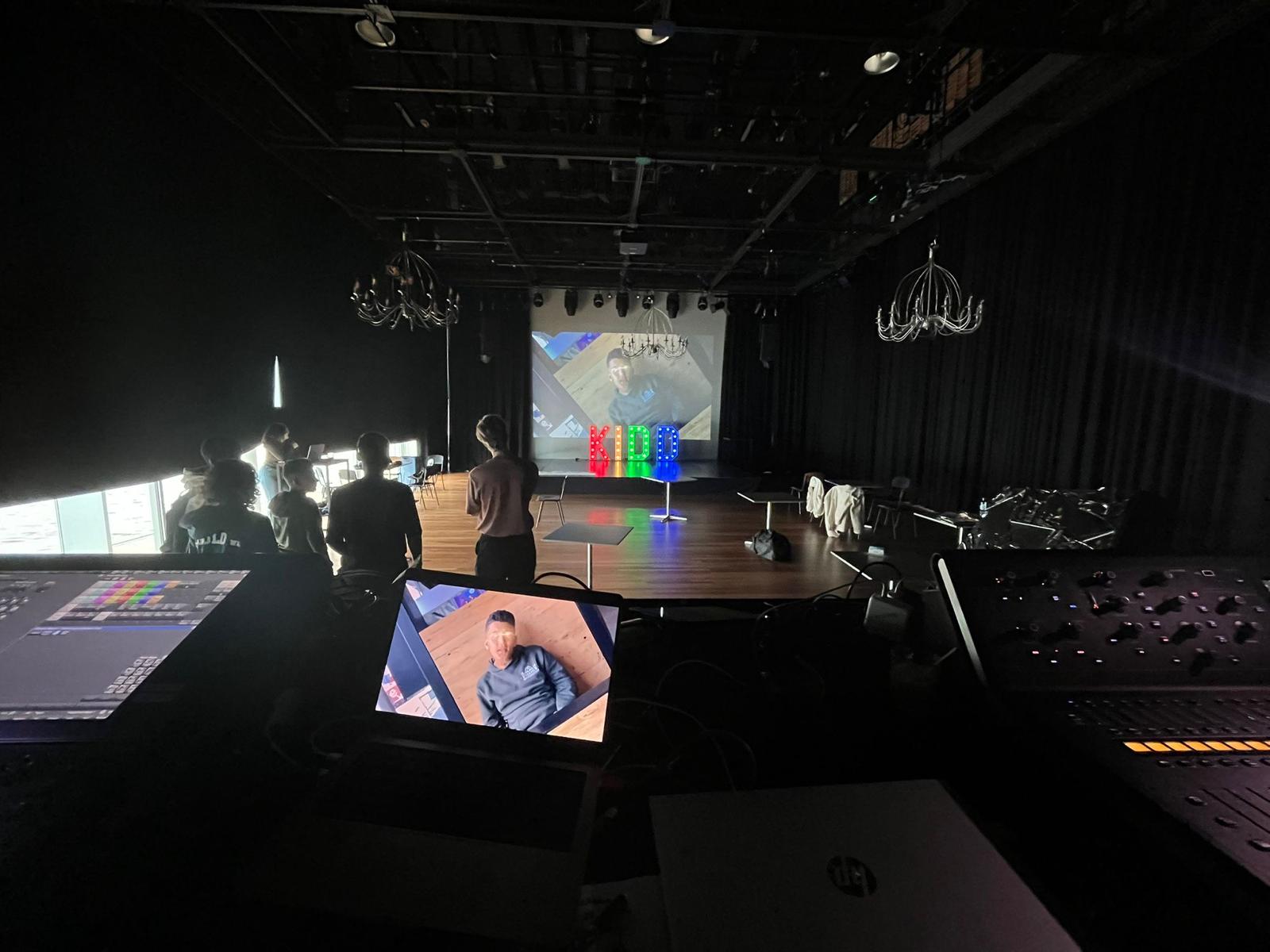Donkere zaal met kinderen en verlichte letters KIDD