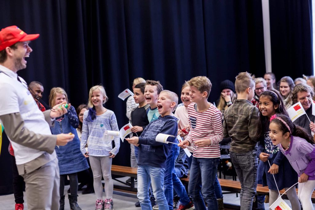 Lachende kinderen met vlaggetjes op een podium