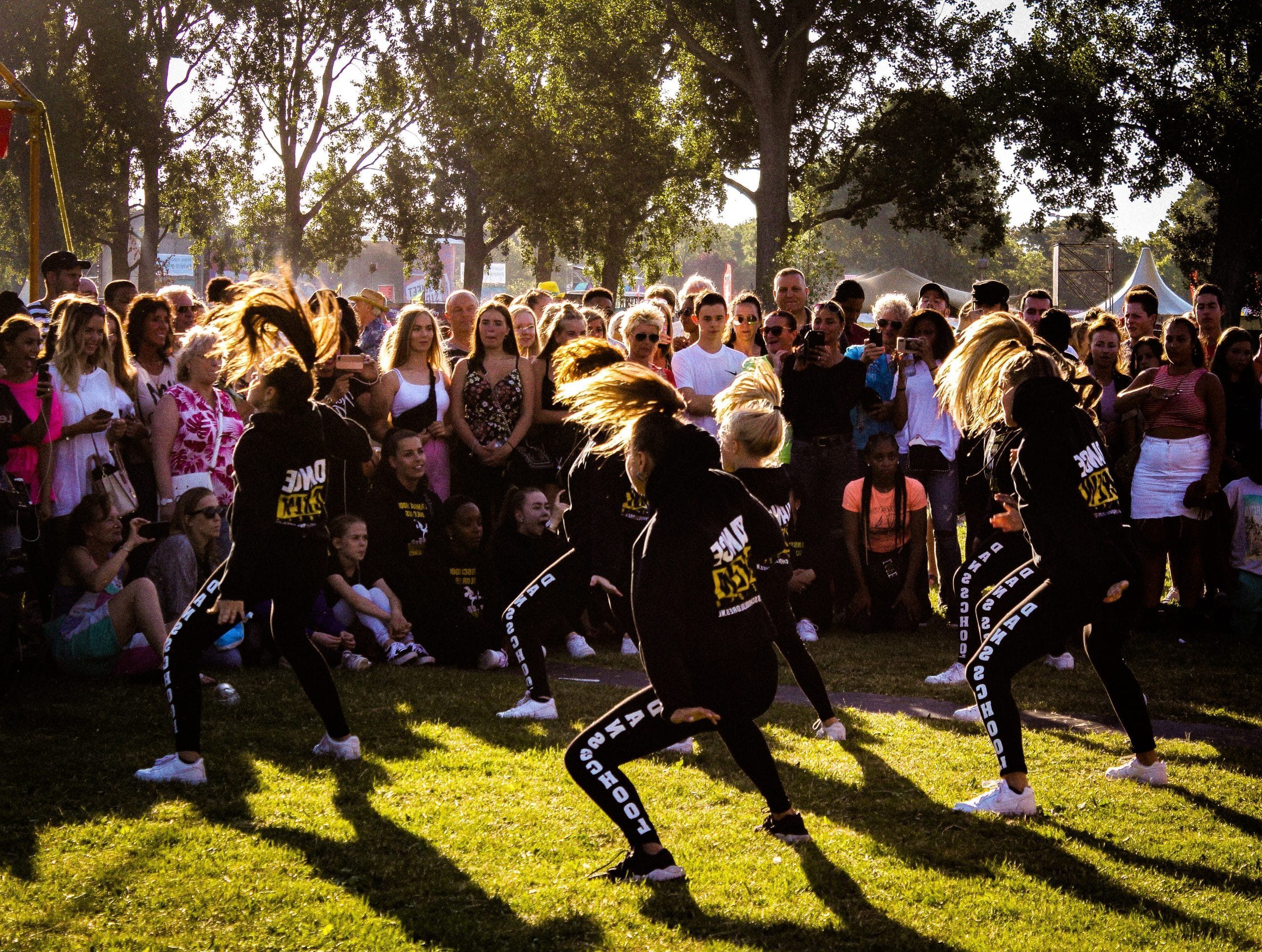 Groep dansers voor publiek, ze zijn buiten