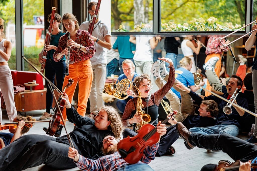 Lachende jongeren met instrumenten op de grond