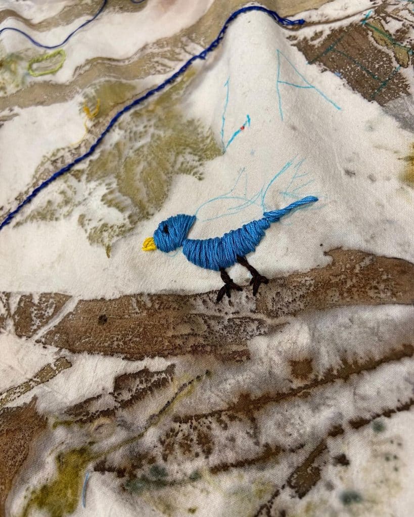 Geborduurde vogel op doek