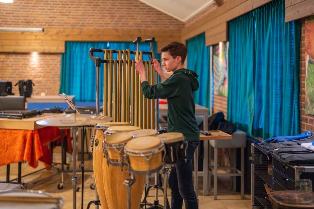 Een jongen bespeelt trommels